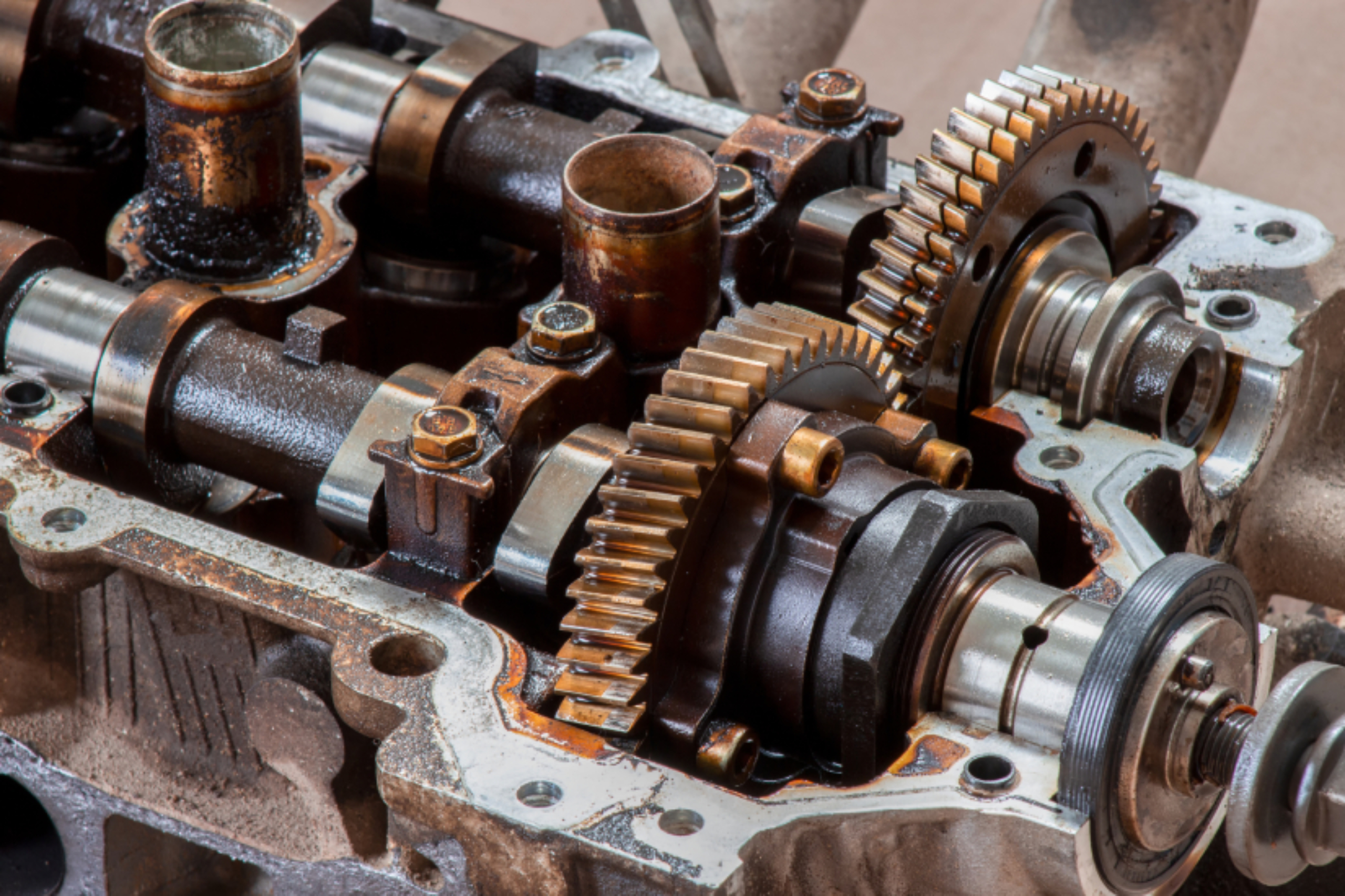 Overhead view of exposed internal metallic gears, shafts, and mechanical components inside a disassembled vehicle transmission.